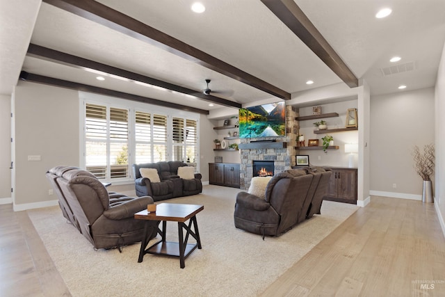 living room with beamed ceiling, a fireplace, visible vents, and baseboards