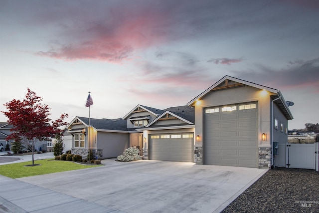 view of front facade with a garage, stone siding, and stucco siding