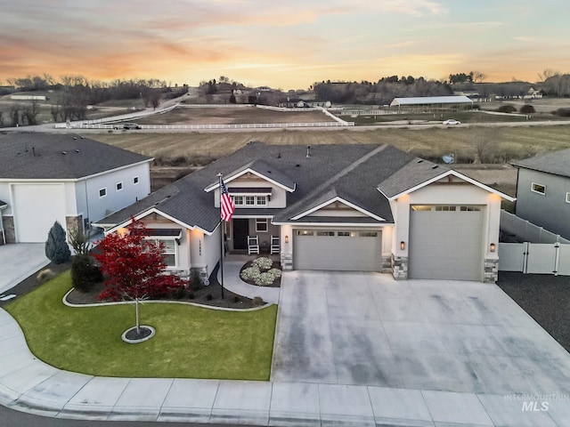 view of front of home featuring an attached garage, a gate, fence, driveway, and a front lawn