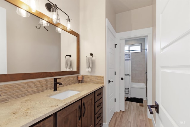 full bathroom featuring shower / tub combo with curtain, wood finished floors, backsplash, and vanity