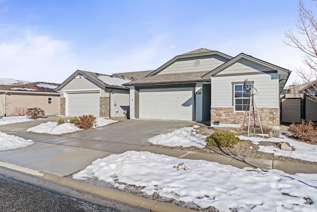 view of front facade with an attached garage, stone siding, and driveway