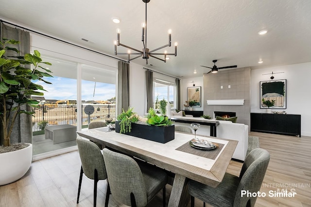5543 E Bridal Veil Falls Dr, Nampa, ID 83686 - dining area with a chandelier, a tiled fireplace, a ceiling fan, recessed lighting, and a water view