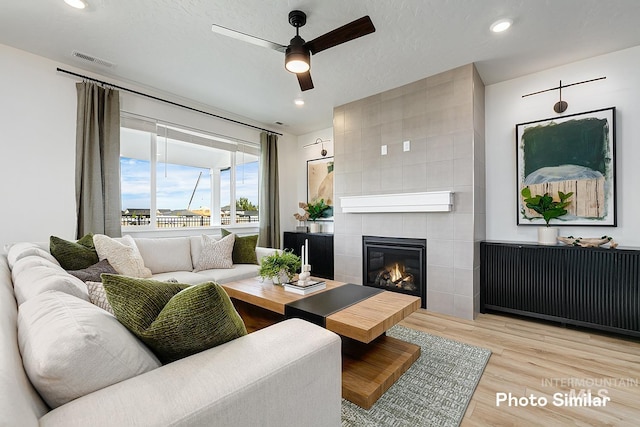 5543 E Bridal Veil Falls Dr, Nampa, ID 83686 - living room with light wood finished floors, a ceiling fan, a fireplace, and recessed lighting