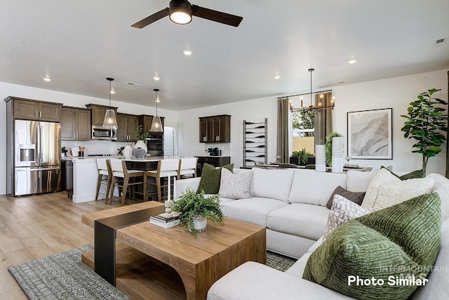 5543 E Bridal Veil Falls Dr, Nampa, ID 83686 - living area with light wood-type flooring, ceiling fan, a chandelier, and recessed lighting