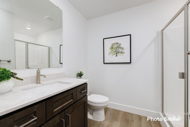5543 E Bridal Veil Falls Dr, Nampa, ID 83686 - bathroom with wood finished floors, a shower stall, toilet, baseboards, and vanity