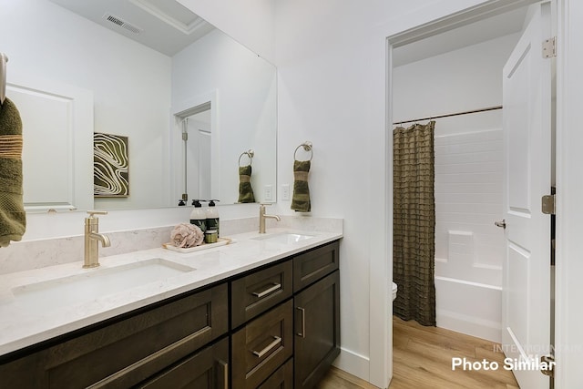5543 E Bridal Veil Falls Dr, Nampa, ID 83686 - bathroom featuring wood finished floors, double vanity, toilet, and shower / bathtub combination with curtain