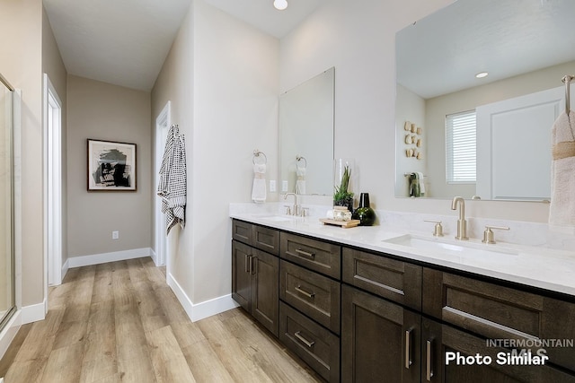 5543 E Bridal Veil Falls Dr, Nampa, ID 83686 - full bathroom with wood finished floors, a shower stall, baseboards, double vanity, and recessed lighting