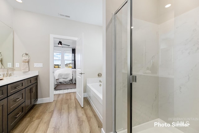 5543 E Bridal Veil Falls Dr, Nampa, ID 83686 - ensuite bathroom with wood finished floors, a stall shower, vanity, a garden tub, and ceiling fan