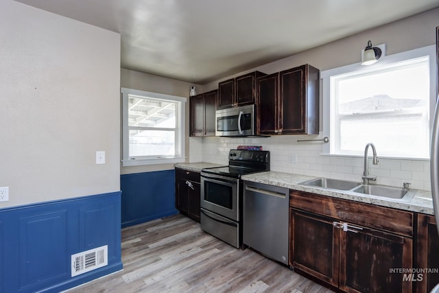 kitchen with visible vents, appliances with stainless steel finishes, light countertops, and a sink