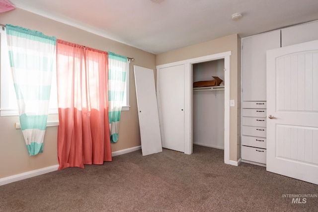 unfurnished bedroom with carpet floors, a closet, and baseboards