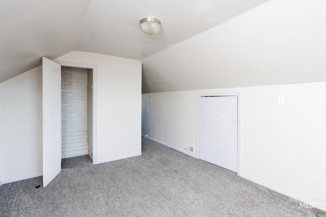 additional living space with vaulted ceiling, carpet flooring, and baseboards