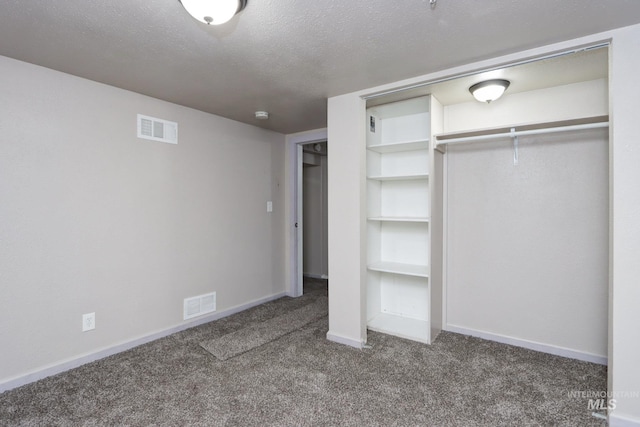 unfurnished bedroom featuring carpet floors, visible vents, and a textured ceiling