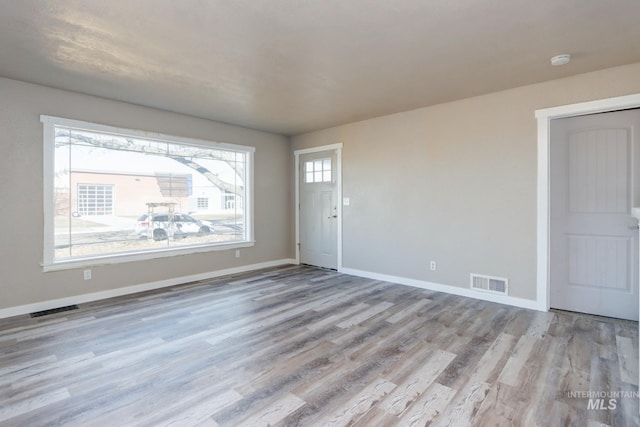 interior space featuring wood finished floors, visible vents, and baseboards