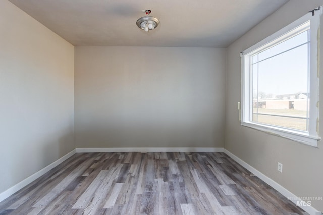 unfurnished room with baseboards and wood finished floors