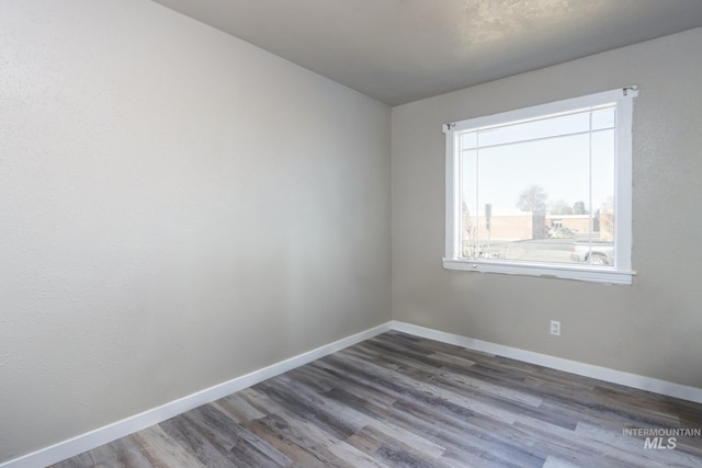 unfurnished room featuring baseboards and wood finished floors