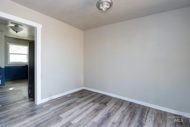 spare room with wood finished floors and baseboards