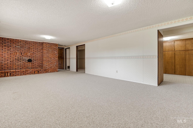 interior space featuring a textured ceiling, carpet floors, and brick wall