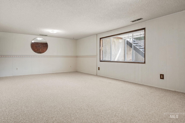 spare room with carpet flooring and a textured ceiling