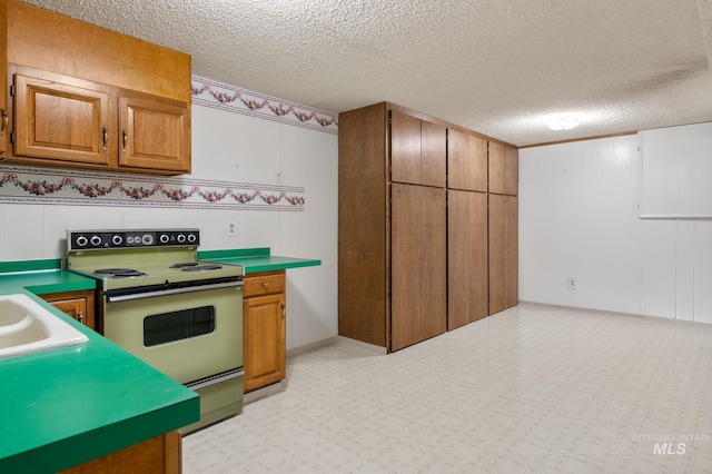 kitchen featuring a textured ceiling and range with electric cooktop