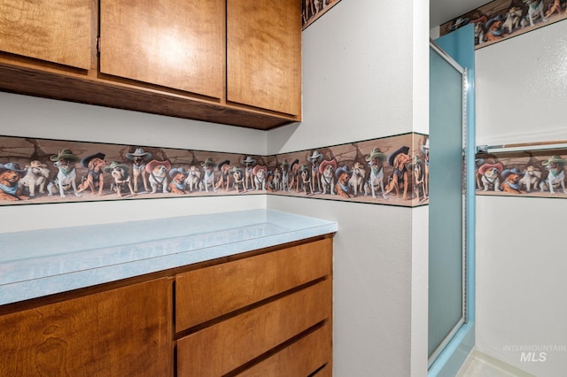 bathroom with vanity and a shower with door