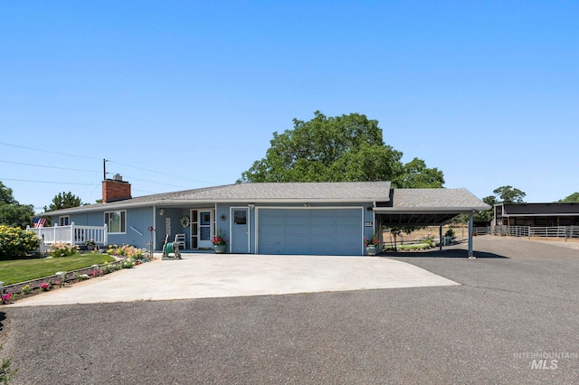 ranch-style home with covered porch, a garage, and a carport