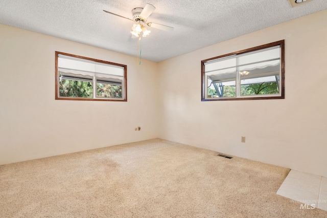 carpeted spare room with ceiling fan and a textured ceiling