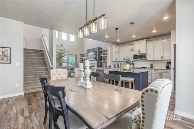 dining area with baseboards, dark wood finished floors, stairway, and recessed lighting