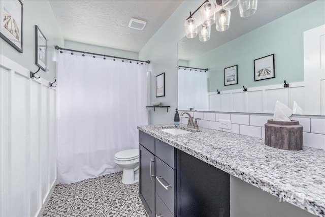 bathroom featuring tasteful backsplash, toilet, vanity, a textured ceiling, and tile patterned floors