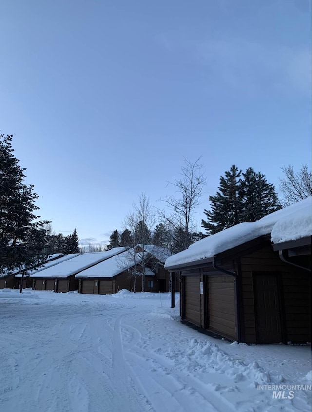 snowy yard featuring an outbuilding