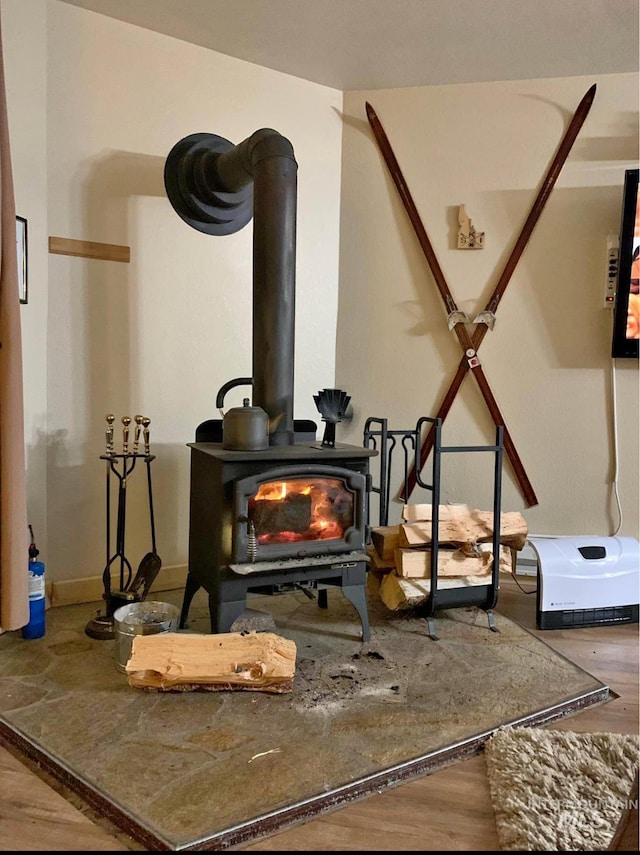 room details with hardwood / wood-style flooring and a wood stove