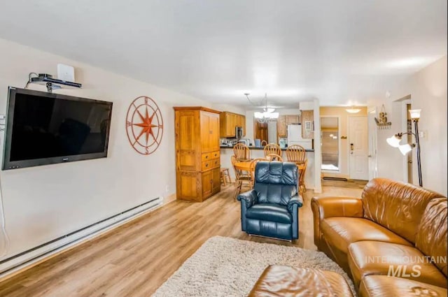 living room with a baseboard radiator, a chandelier, and light hardwood / wood-style flooring