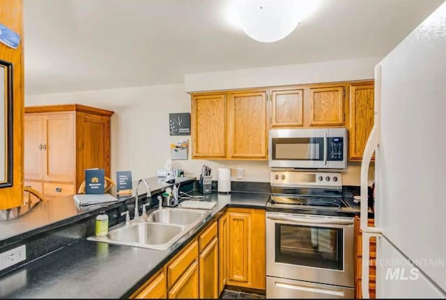1630 N Davis Ave Unit 19, Mccall, ID 83638 - kitchen featuring stainless steel appliances, a sink, dark countertops, and brown cabinetry