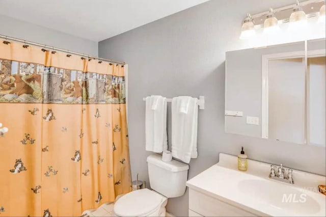 bathroom featuring vanity, toilet, and curtained shower