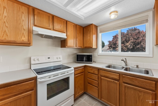 816 W Georgia Ave, Nampa, ID 83686 - kitchen featuring electric stove, a sink, under cabinet range hood, light countertops, and brown cabinets