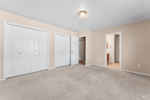 816 W Georgia Ave, Nampa, ID 83686 - unfurnished bedroom featuring two closets, carpet flooring, baseboards, and ensuite bathroom