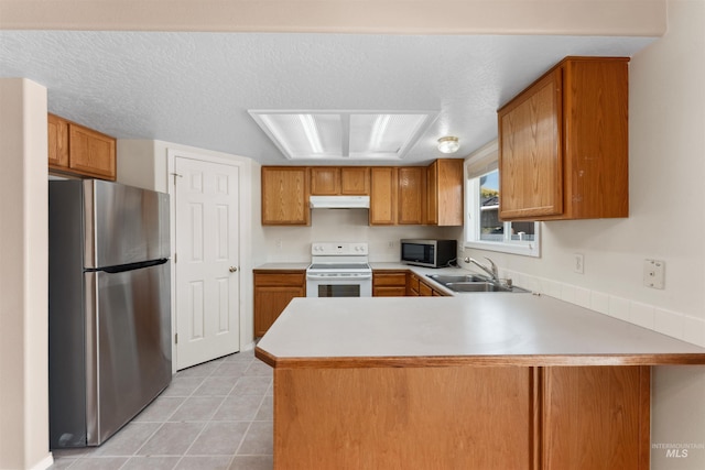 816 W Georgia Ave, Nampa, ID 83686 - kitchen with stainless steel appliances, under cabinet range hood, a sink, a peninsula, and brown cabinets