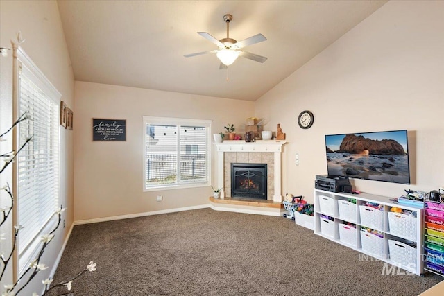 carpeted living room with lofted ceiling, a tile fireplace, and ceiling fan