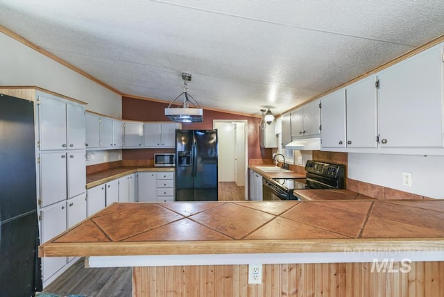 kitchen featuring a peninsula, under cabinet range hood, a sink, black appliances, and vaulted ceiling