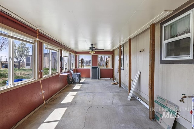 unfurnished sunroom featuring ceiling fan and a healthy amount of sunlight
