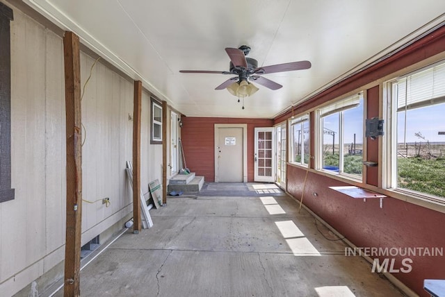 unfurnished sunroom with a ceiling fan