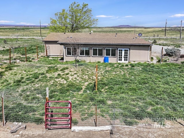 back of house featuring fence and french doors