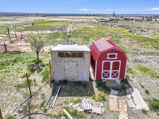 view of shed featuring fence and a rural view