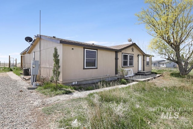 view of side of property with crawl space and fence