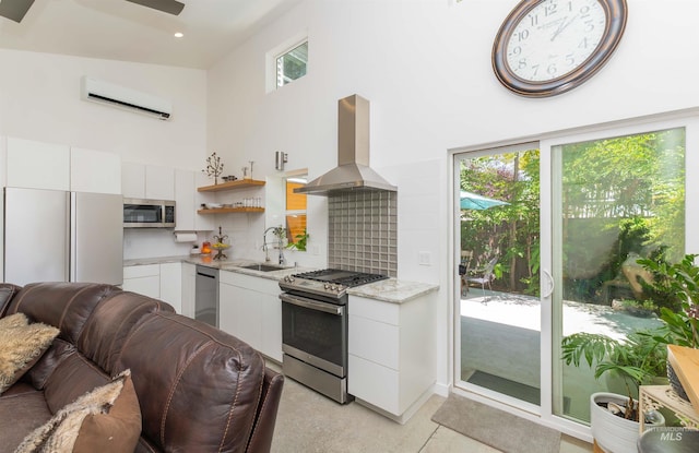 712 E Sheridan, Nampa, ID 83686 - kitchen with stainless steel appliances, wall chimney exhaust hood, a wall mounted AC, a towering ceiling, and white cabinets