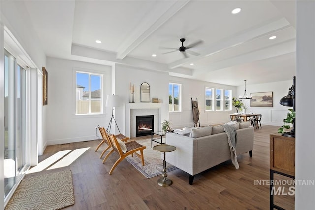 living room with beam ceiling, dark wood-type flooring, and ceiling fan