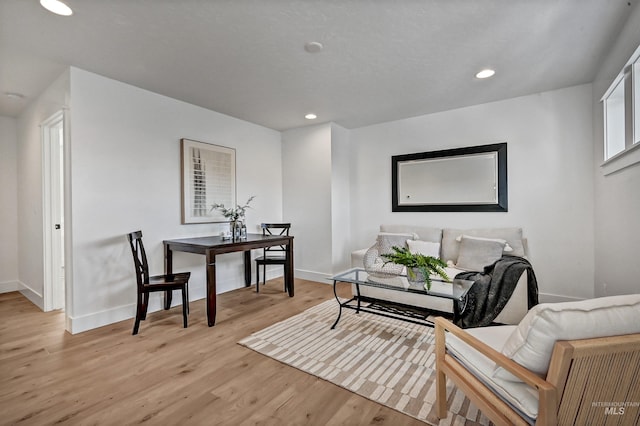 living area with recessed lighting, light wood-type flooring, and baseboards