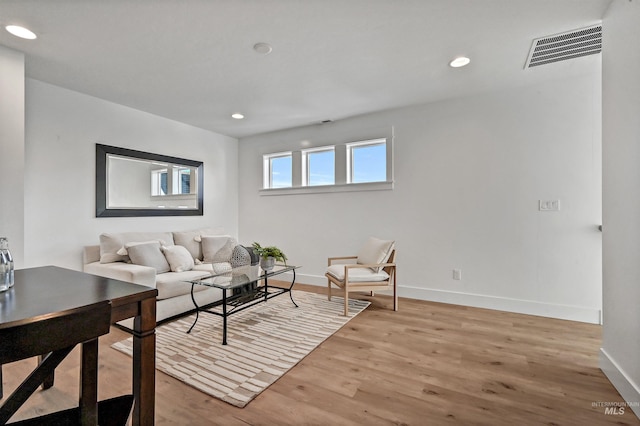 living area featuring visible vents, recessed lighting, baseboards, and wood finished floors