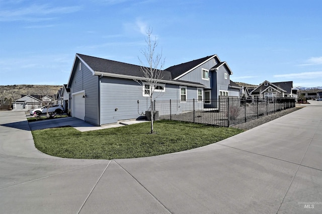 view of home's exterior featuring fence, driveway, a garage, a lawn, and a residential view