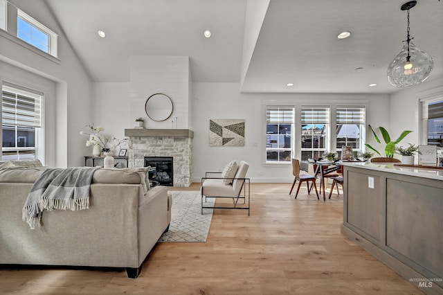 living area featuring recessed lighting, light wood-style flooring, a fireplace, and baseboards