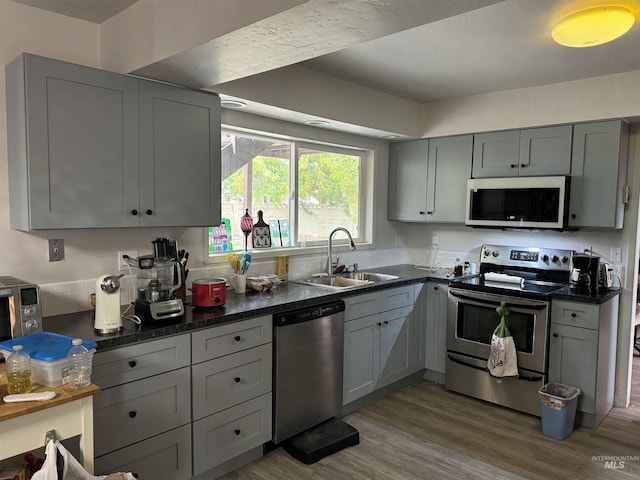 1111 SW 11th Ave, Ontario, OR 97914 - kitchen featuring stainless steel appliances, dark wood-style flooring, a sink, and gray cabinets